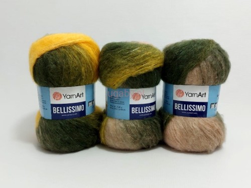 Trzy motki puszystej włóczki YarnArt Bellissimo numer koloru 1410 w melanżowych odcieniach butelkowej zieleni, miodowego żółtego i beżu.